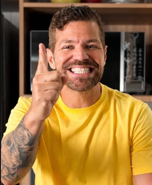Post do Instagram: homem sorrindo de camiseta amarela